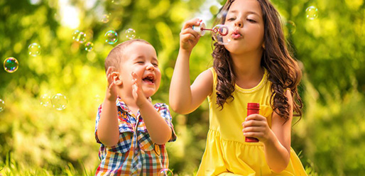 2 kids playing outside in the garden