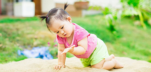 baby playing in sand